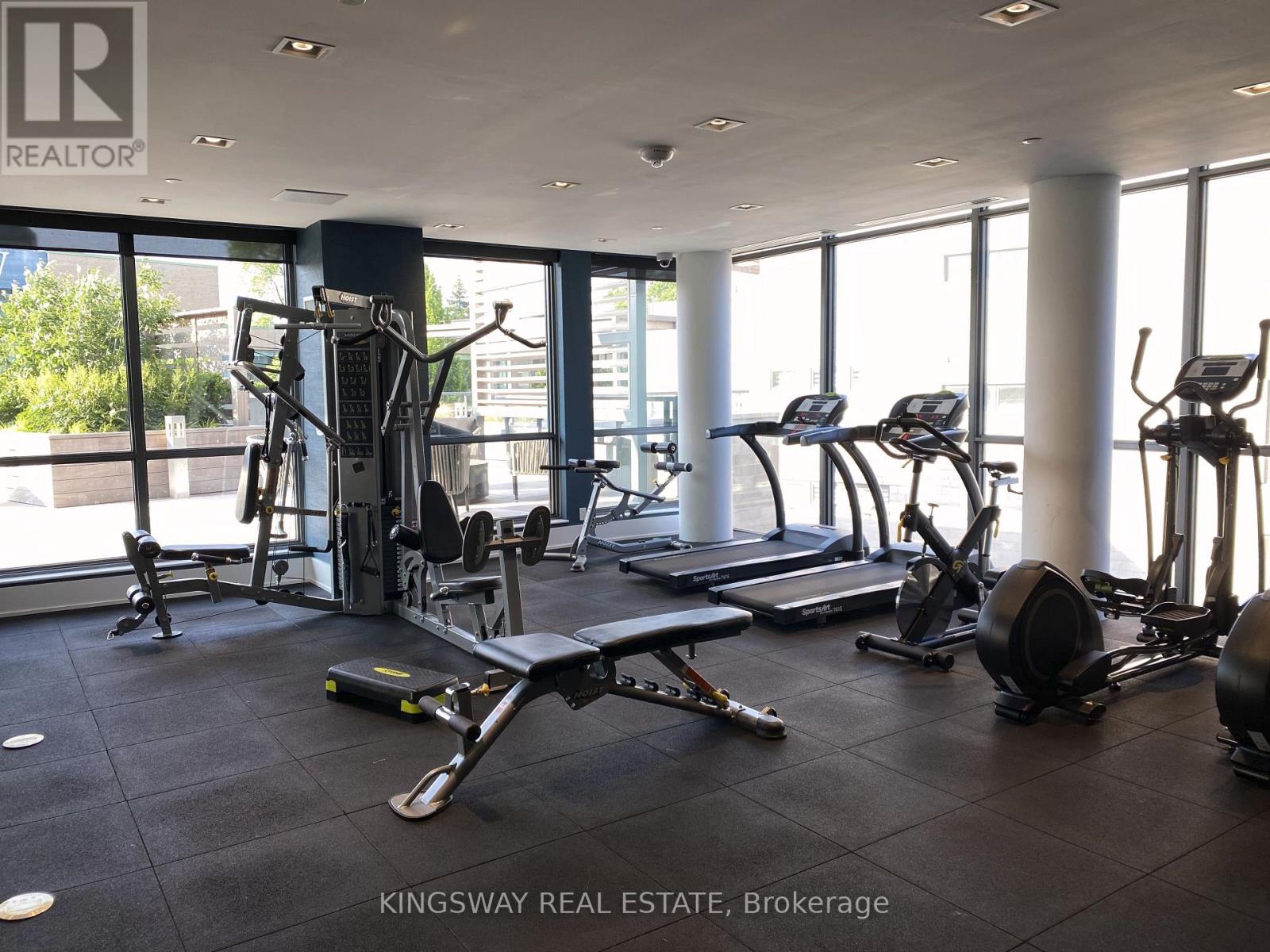 A gym with a variety of equipment including treadmills, weights, and exercise machines.
