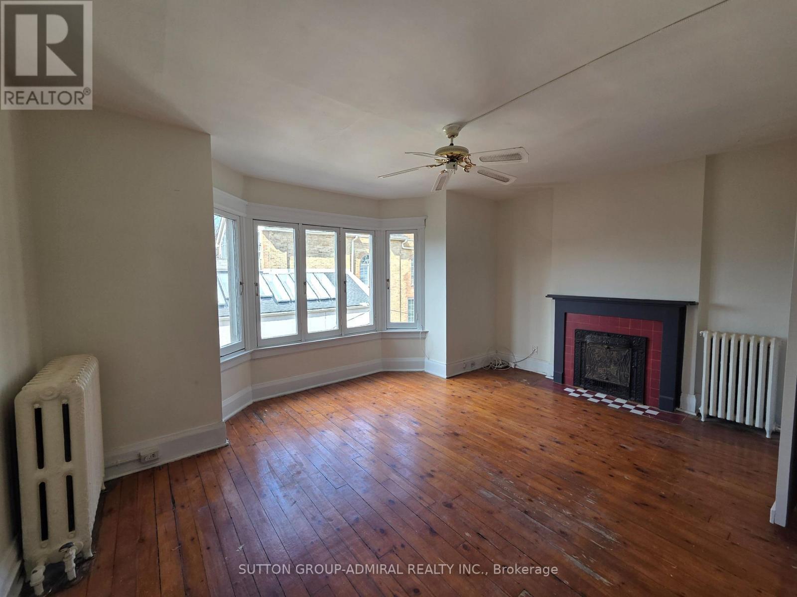 A room with a fireplace and a fan.