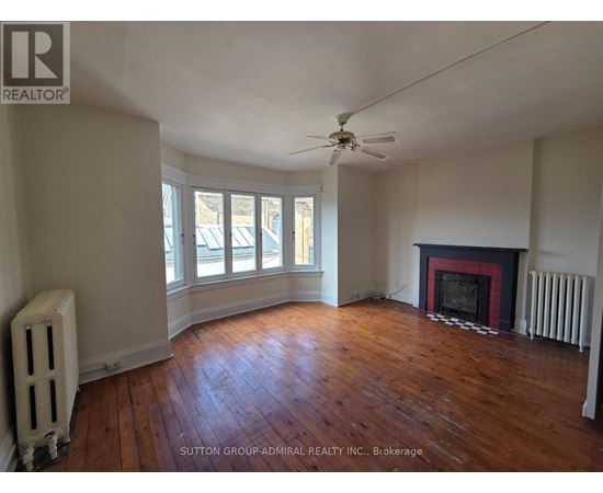 A room with a fireplace and a fan.