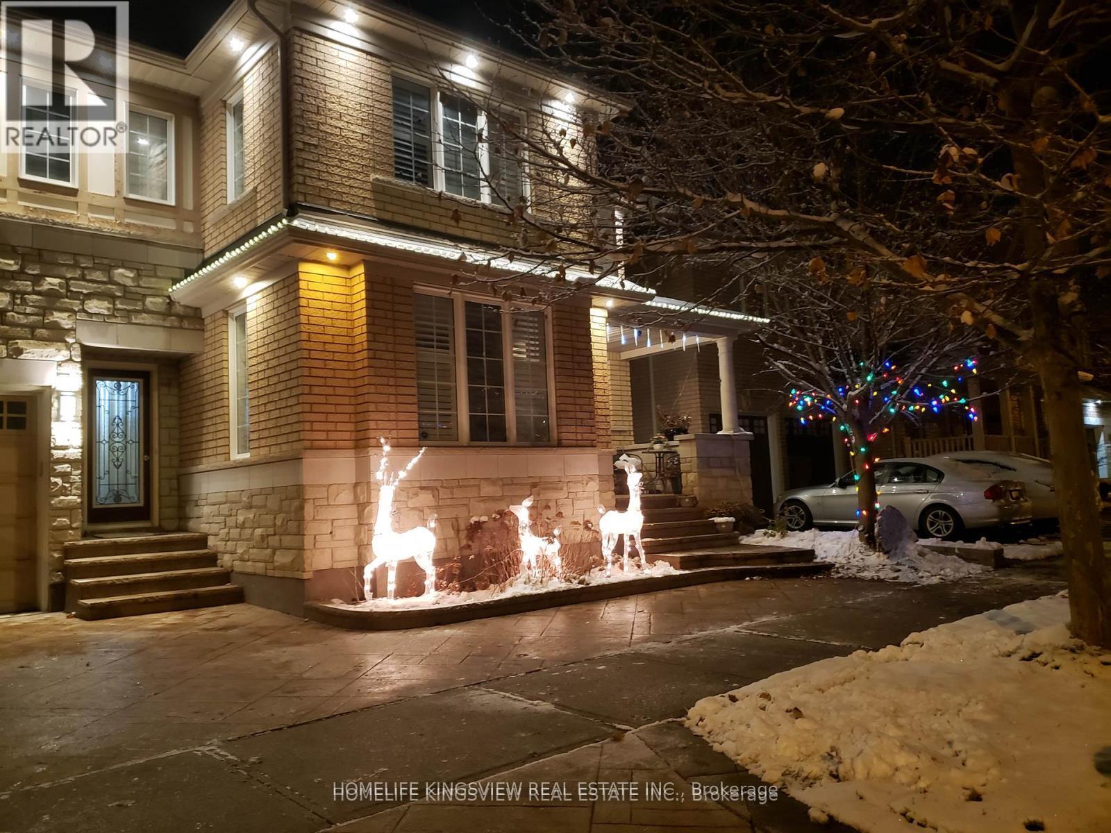 A house with a lit up reindeer and a tree in front of it.