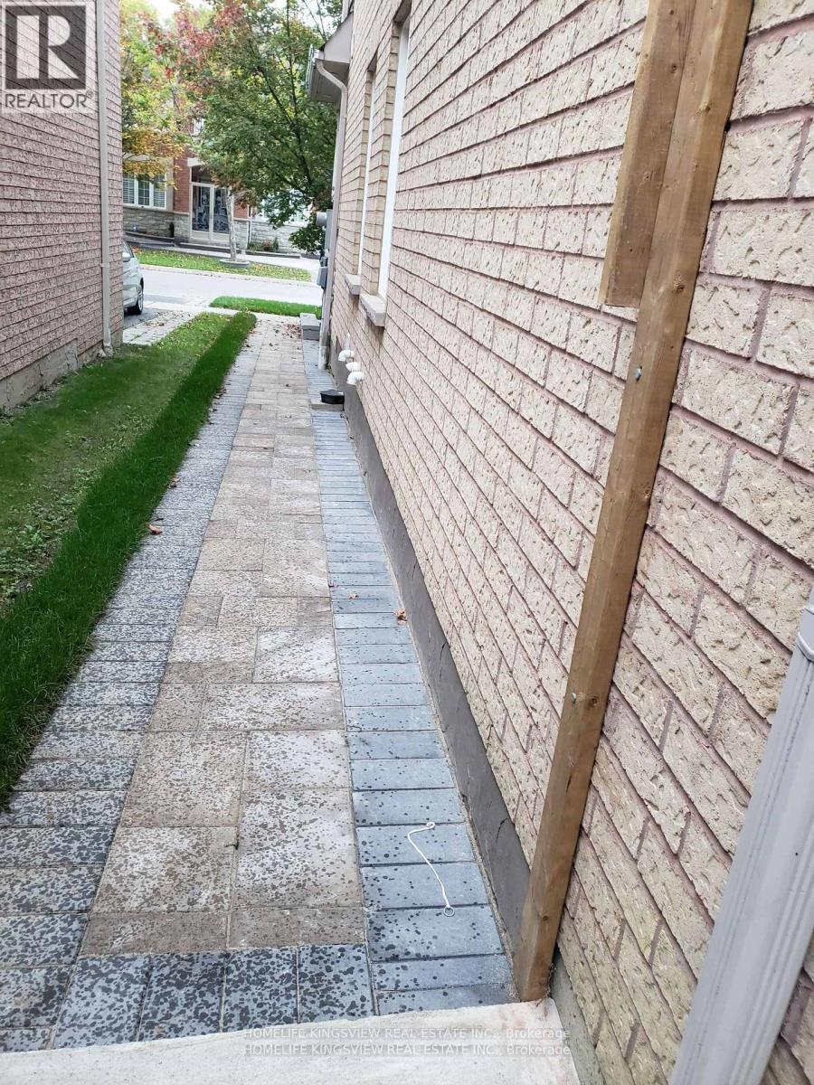 A brick wall with a wooden post in the corner.