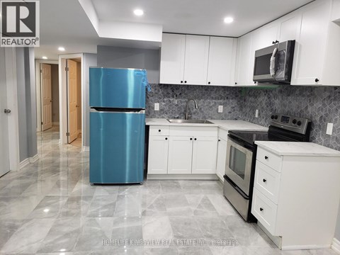 A kitchen with a blue refrigerator and white cabinets.