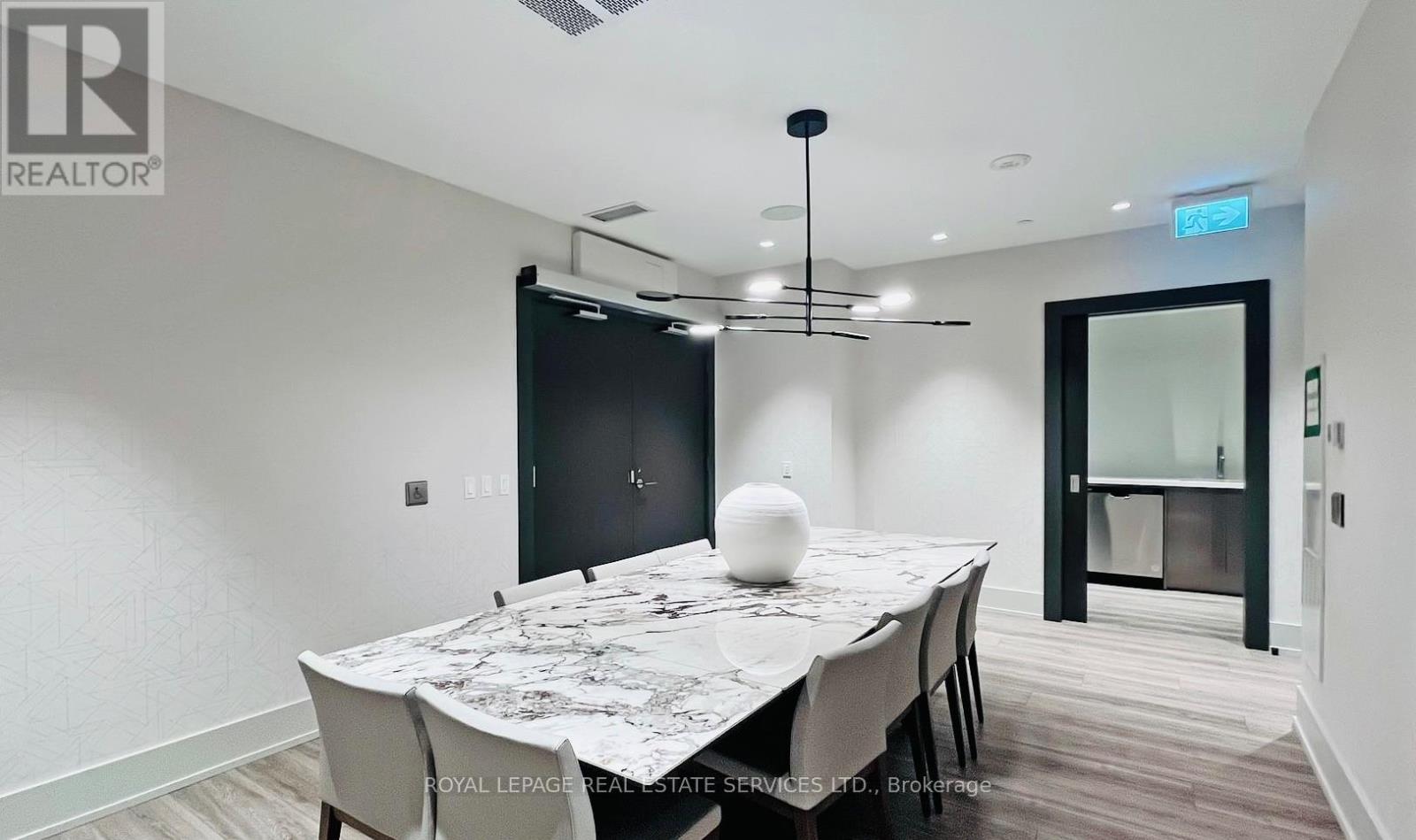 A dining room with a table set for two and a black door.