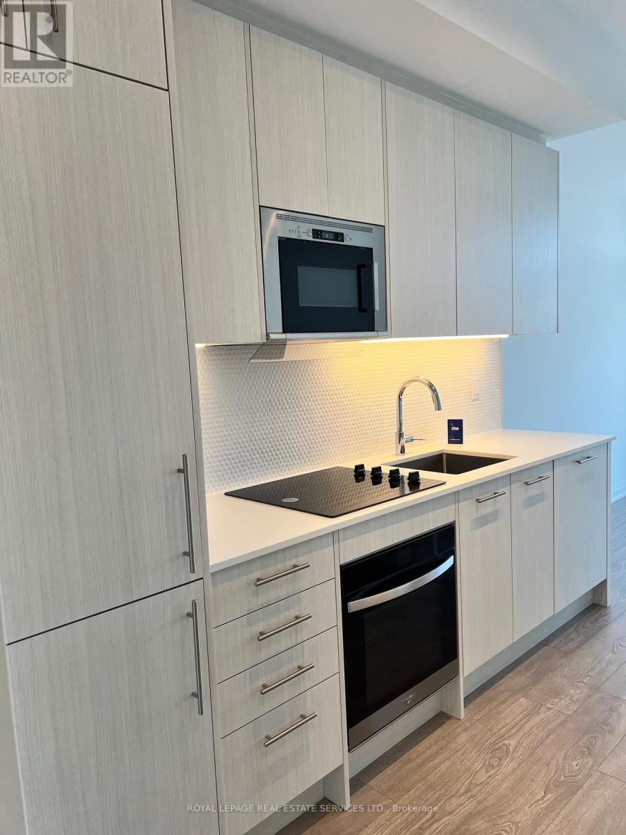 A modern kitchen with white cabinets and a microwave above the stove.