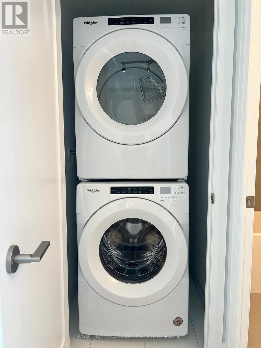 Two white Whirlpool washing machines in a small laundry room.