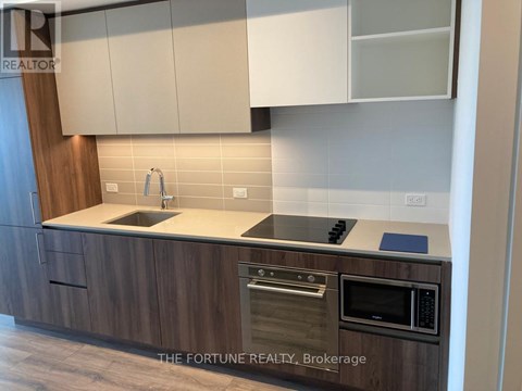 A kitchen with wooden cabinets and a modern design.