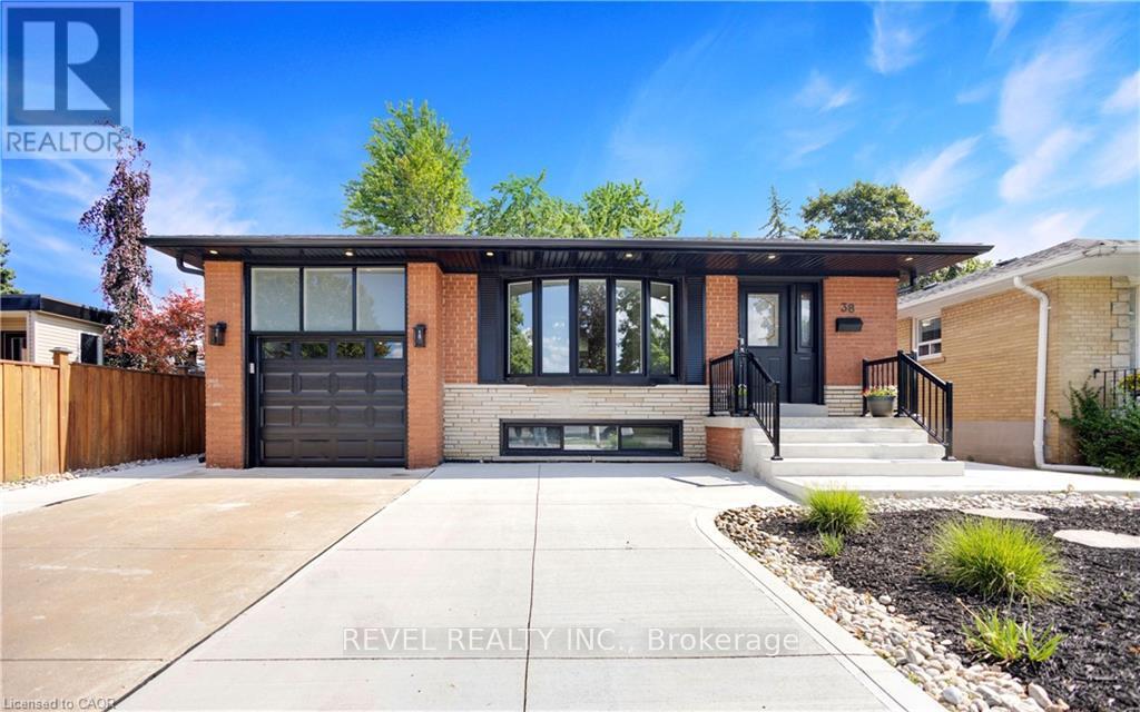 A modern house with a black garage door is for sale.