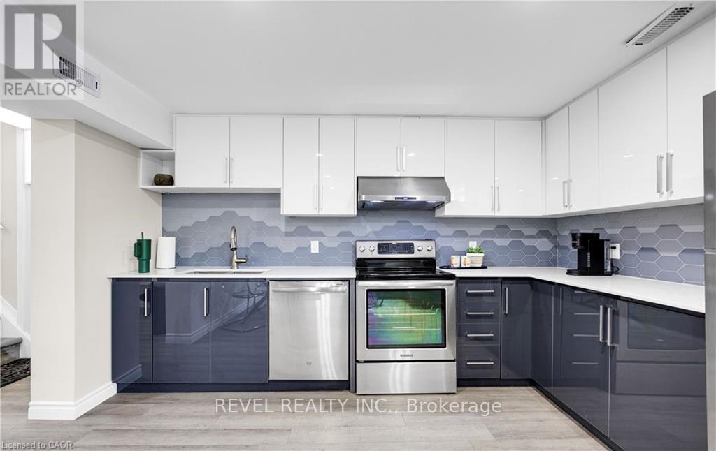 A modern kitchen with white cabinets and a grey backsplash.