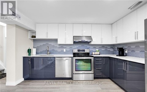 A modern kitchen with white cabinets and a grey backsplash.