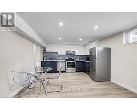 A modern kitchen with a glass table and stainless steel appliances.