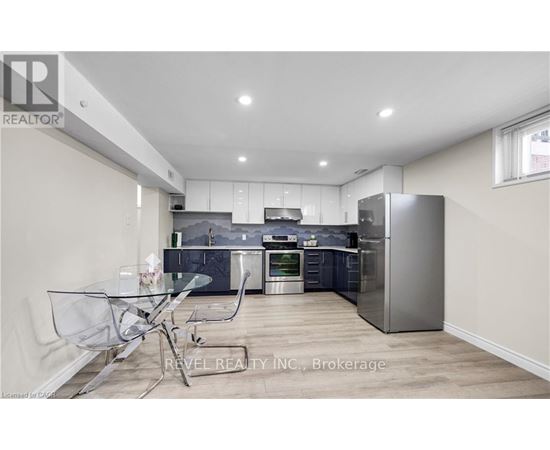 A modern kitchen with a glass table and stainless steel appliances.
