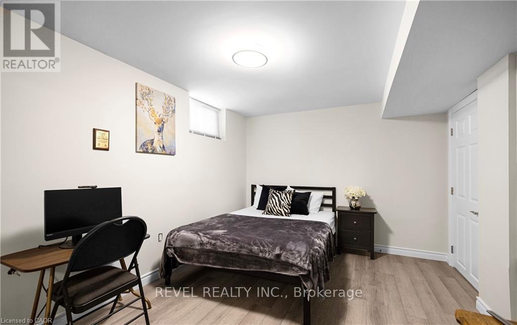 A bedroom with a bed, chair, and a painting on the wall.