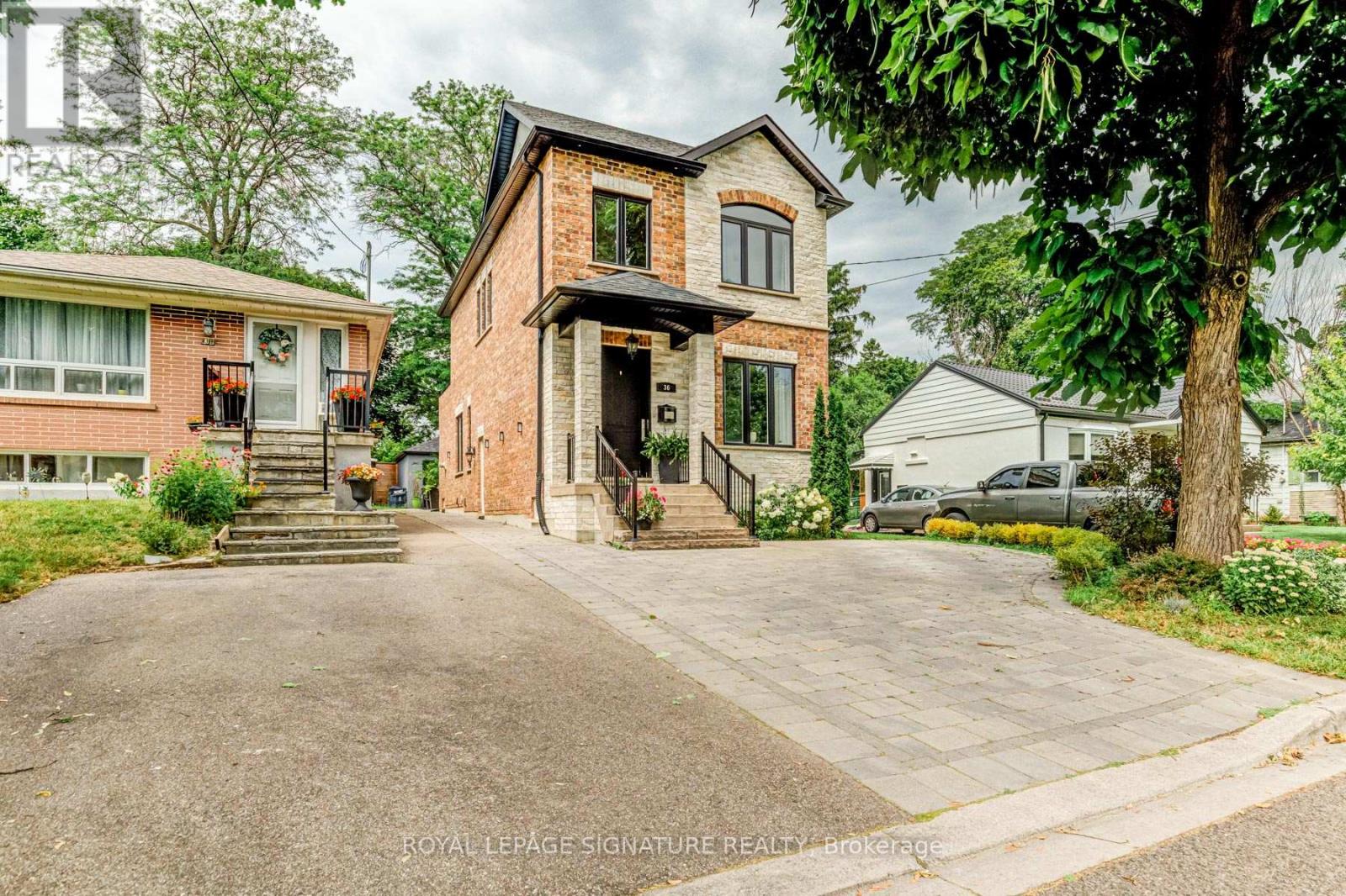 A brick house with a driveway in front of it.
