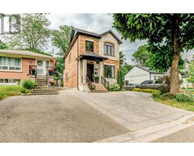 A brick house with a driveway in front of it.