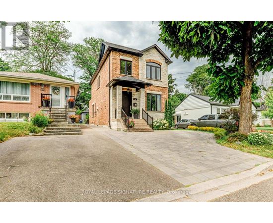 A brick house with a driveway in front of it.