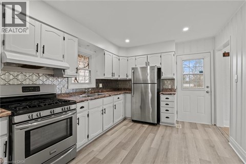 A modern kitchen with white cabinets and stainless steel appliances.