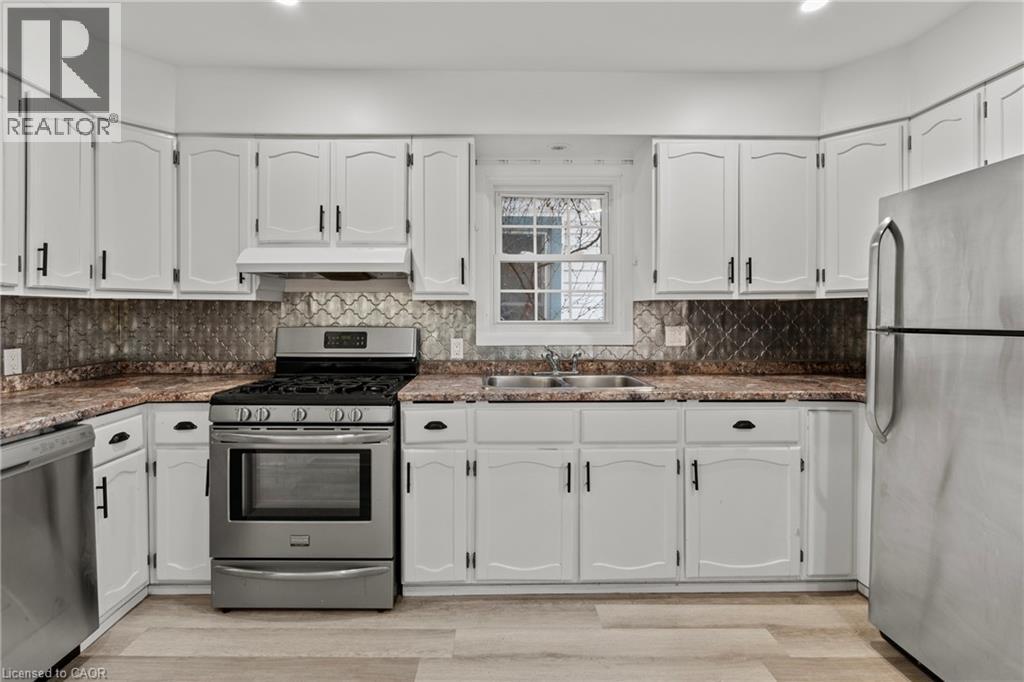 A kitchen with white cabinets and a black stove top oven.