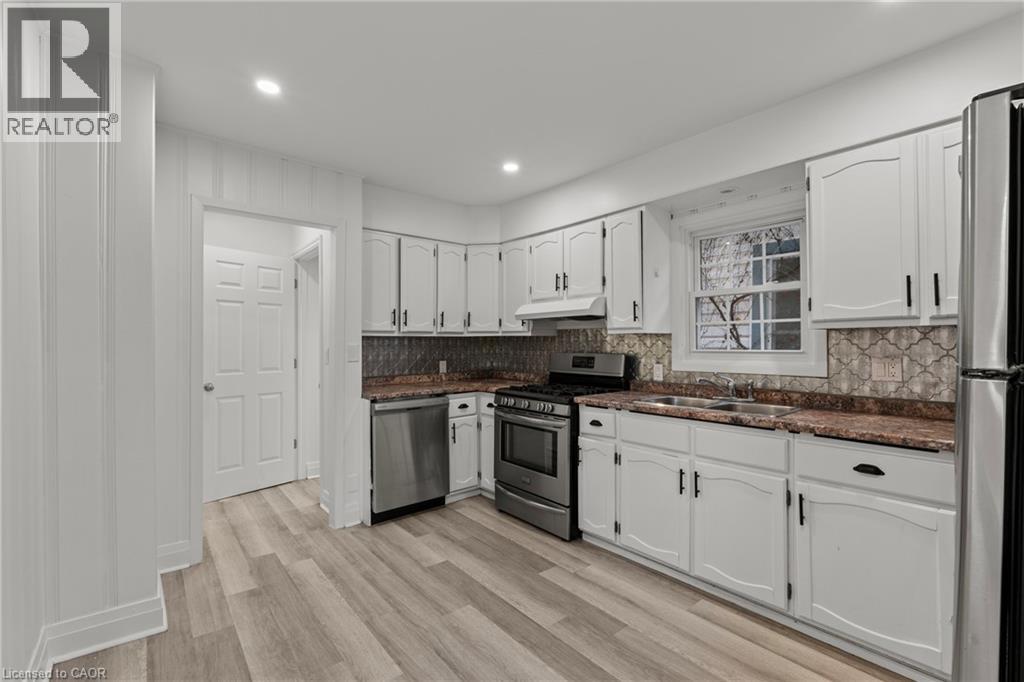 A kitchen with white cabinets and a refrigerator.