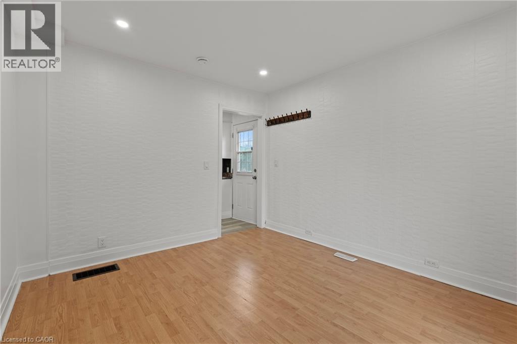 A room with wooden flooring and white walls.