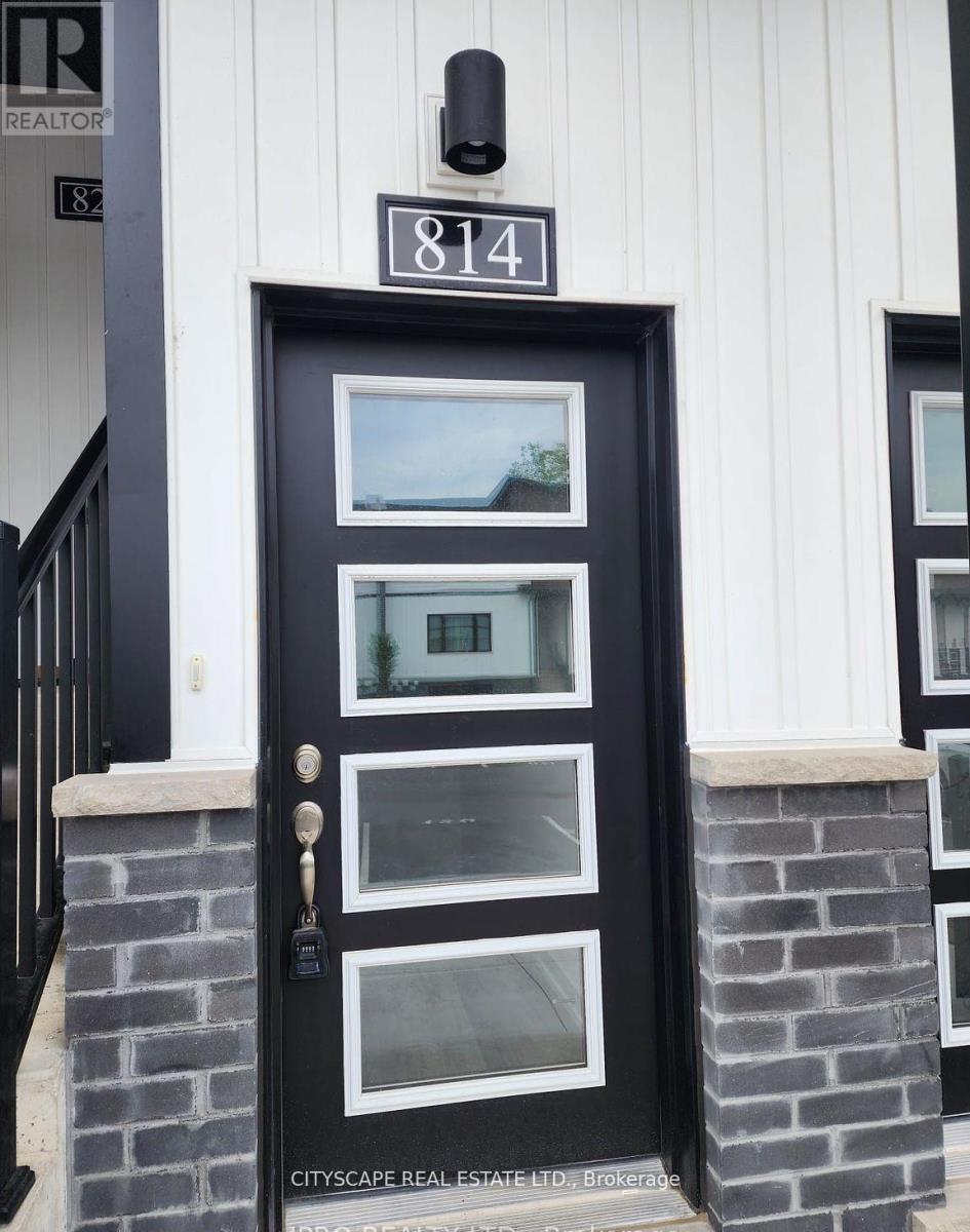 A black door with a glass window and a sign above it that says 814.