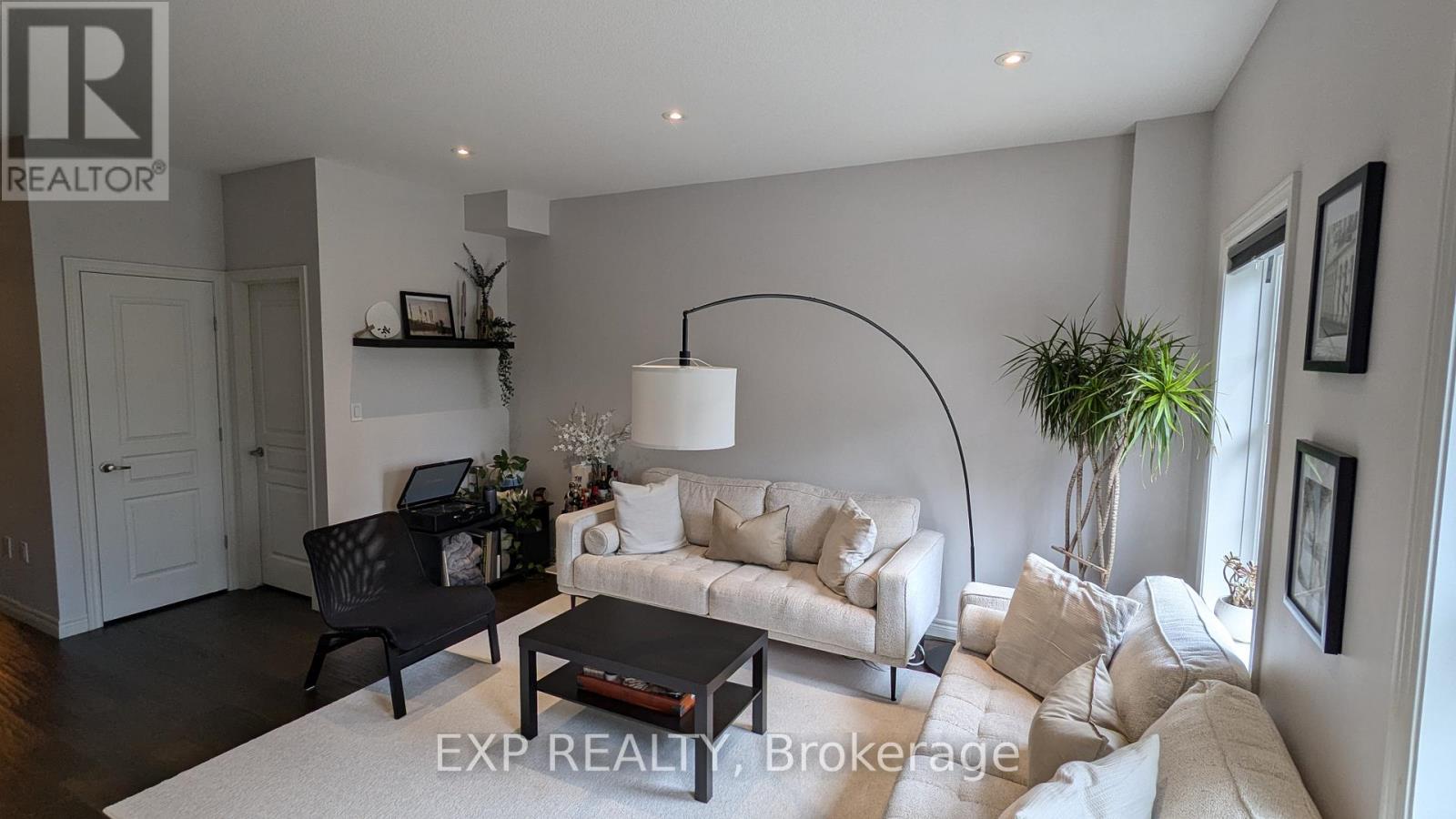 A living room with a black chair, a white couch, and a black coffee table.
