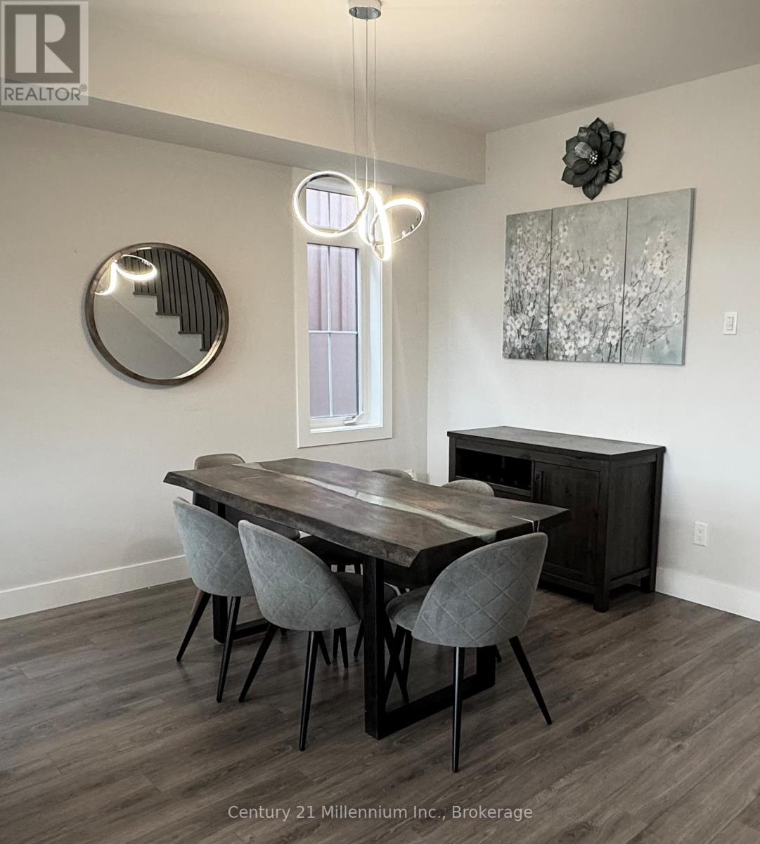 A dining room with a wooden table and grey chairs.