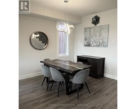 A dining room with a wooden table and grey chairs.