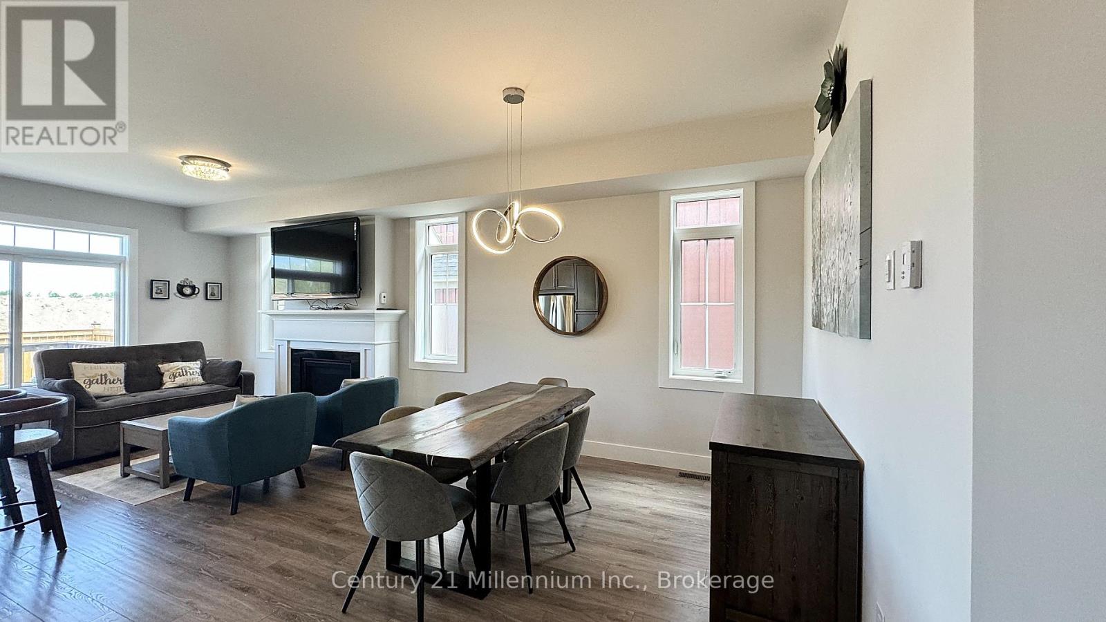 A well-lit living room with a fireplace and a dining table set up.