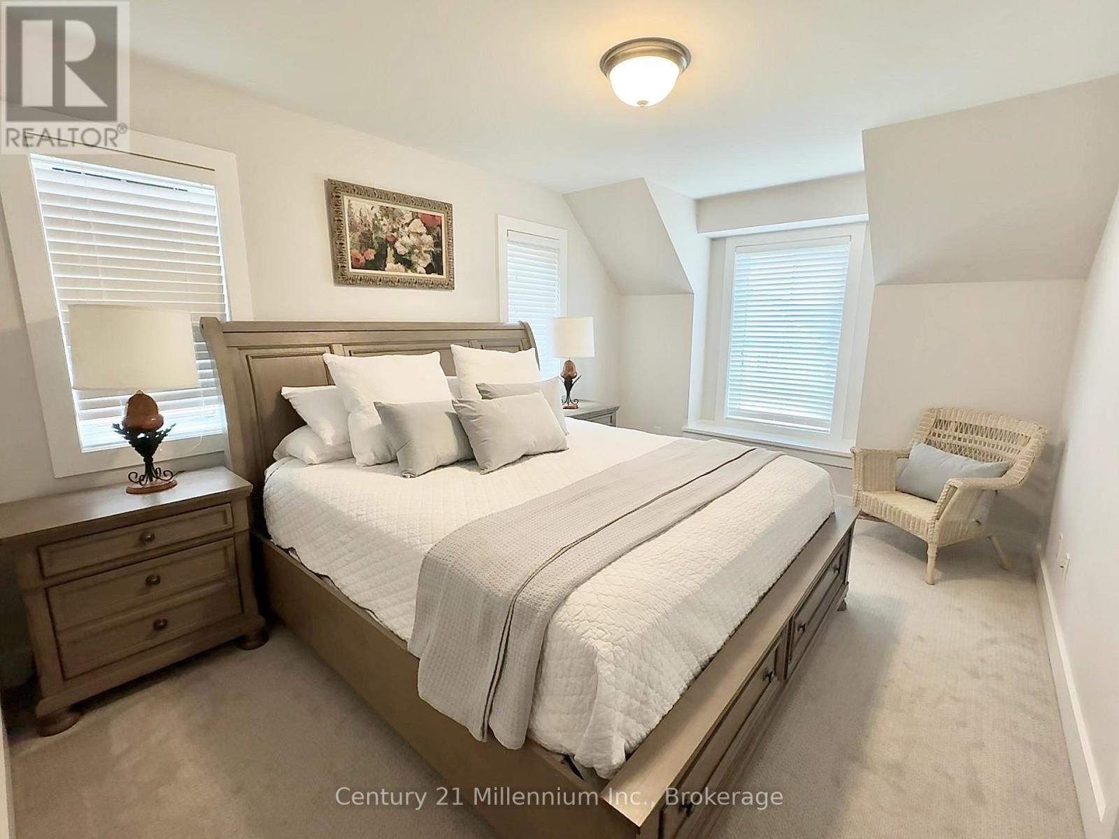 A bedroom with a large bed and a painting on the wall.