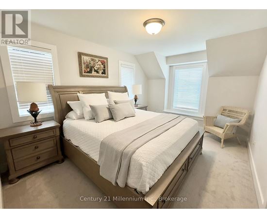 A bedroom with a large bed and a painting on the wall.