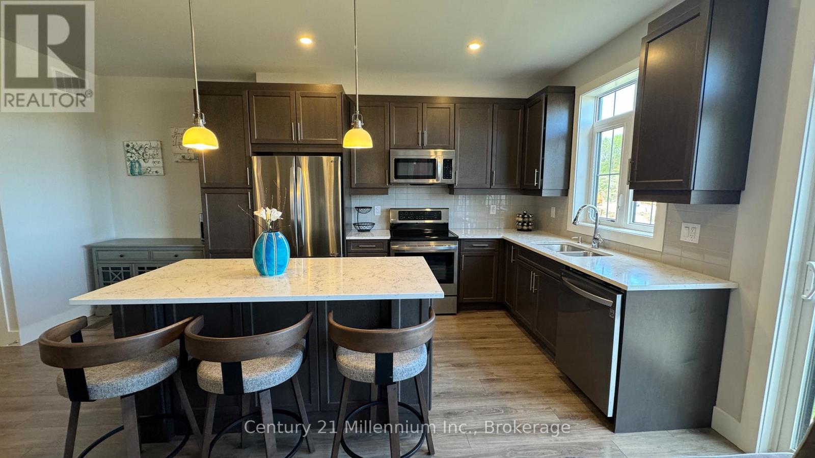 A kitchen with a table and chairs in front of it.