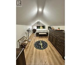 A bedroom with a bed, dresser, and a bicycle on the wall.