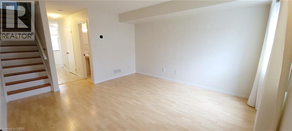 A large empty room with wooden floors and white walls.