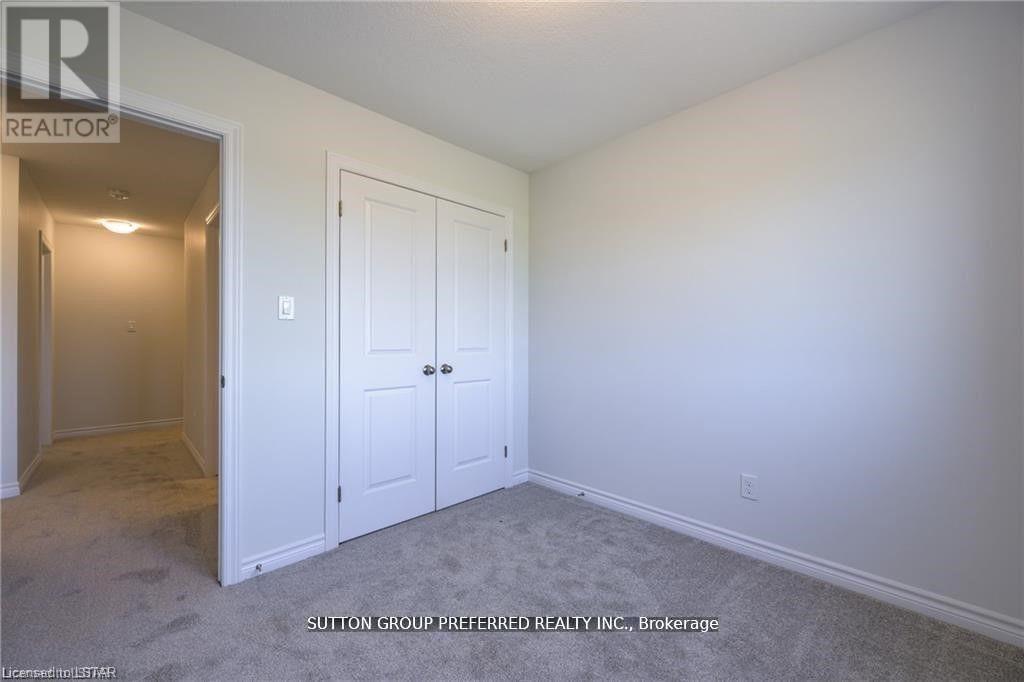 A bedroom with a white door and a white wall.