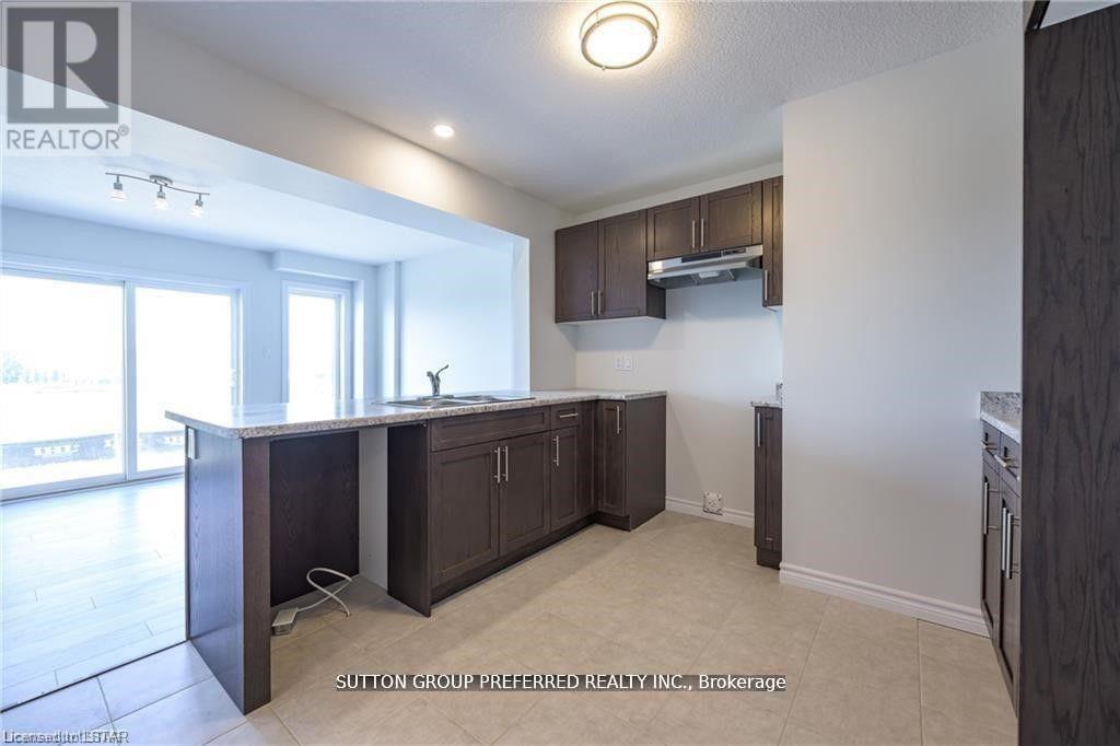 A kitchen with dark wood cabinets and a white countertop.