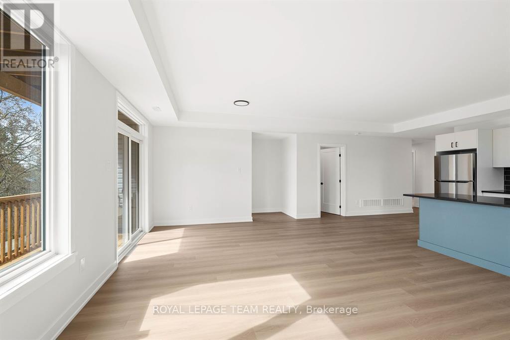 A spacious, empty room with wooden floors and white walls.