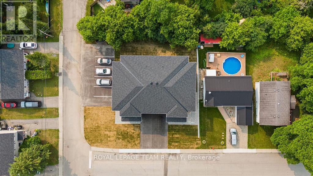 An aerial view of a house with a pool and a car parked in front.