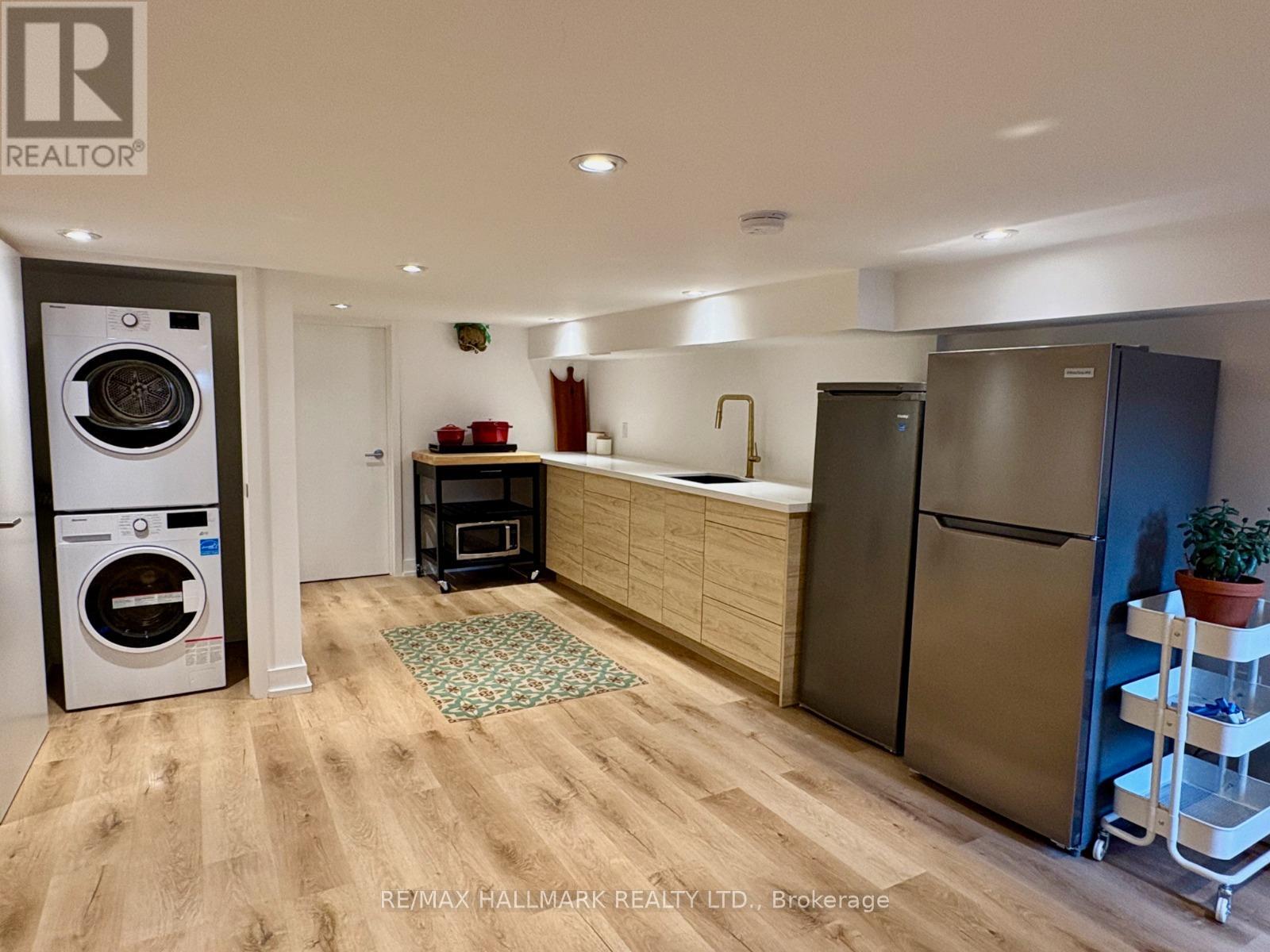 A kitchen with a washing machine and a fridge.