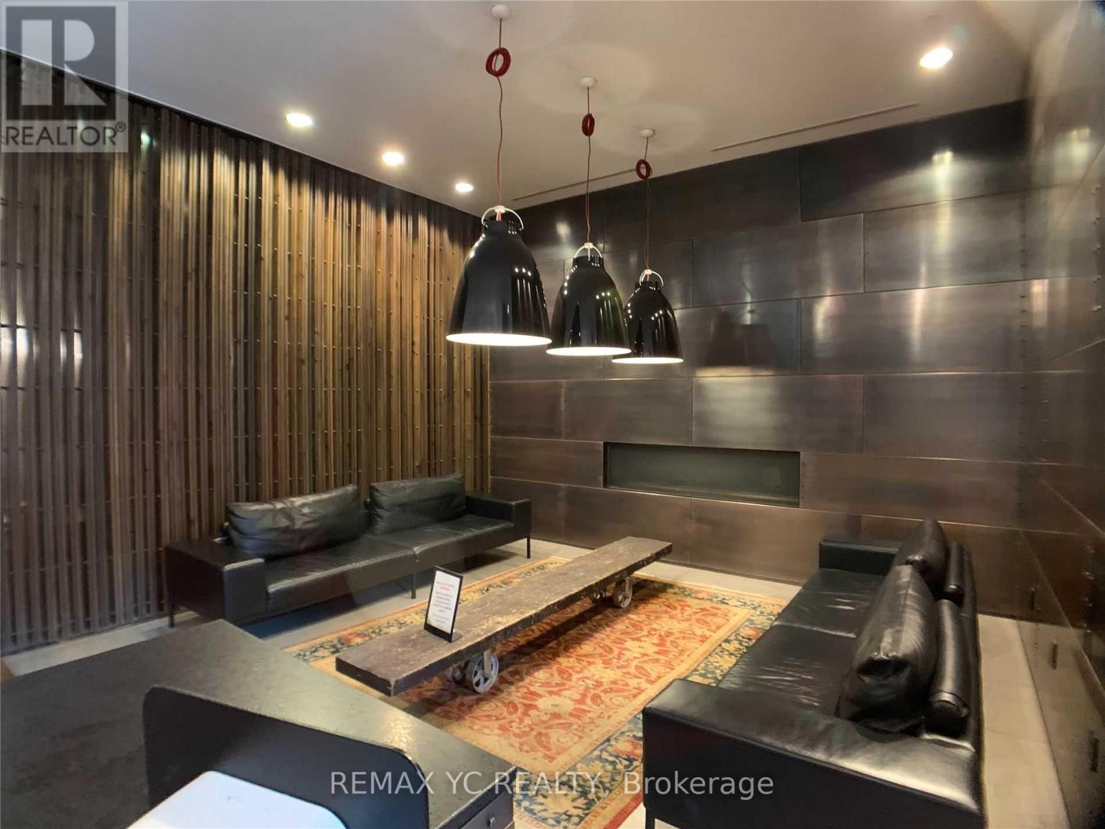 A modern living room with a black couch and a wooden coffee table.