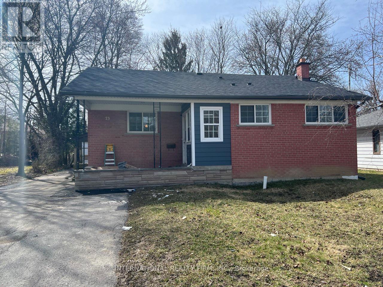 A small red brick house with a white door and a small porch.