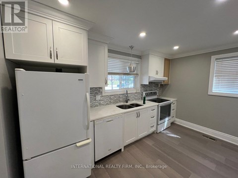A kitchen with white cabinets and appliances.