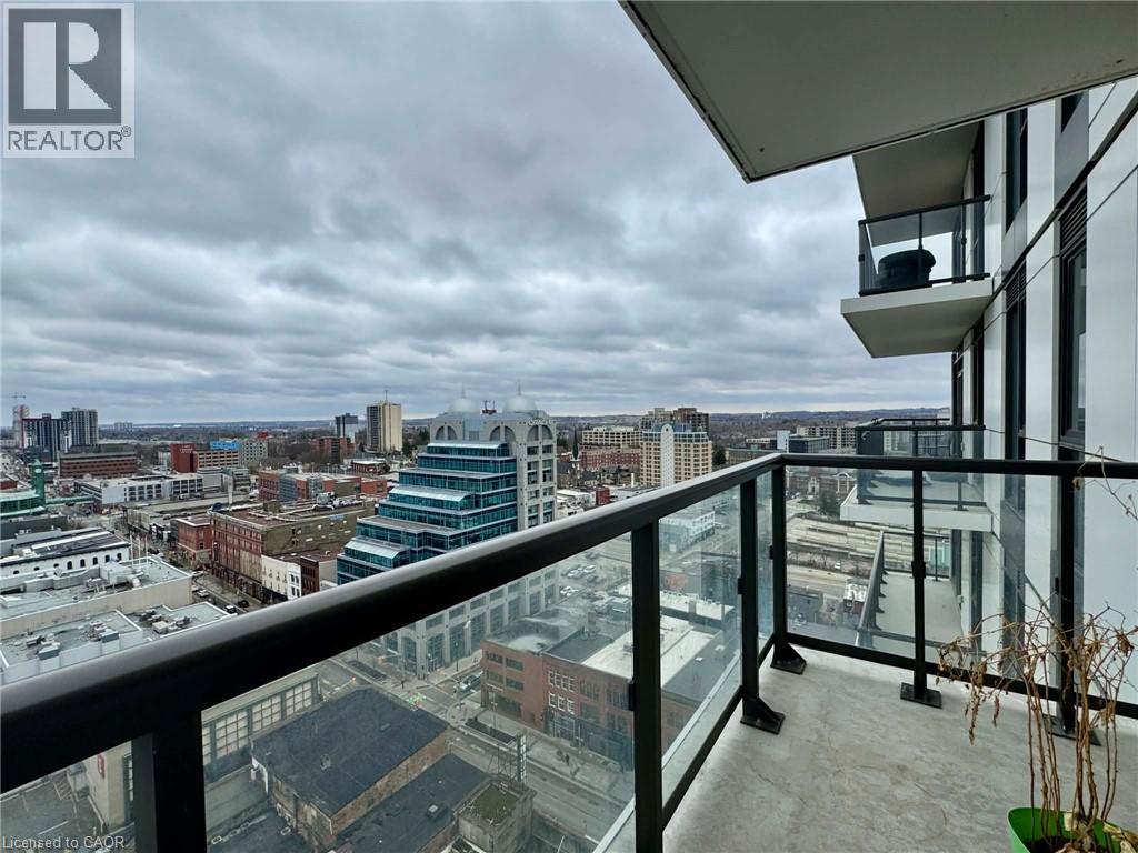 A balcony overlooks a cityscape with buildings and a cloudy sky.