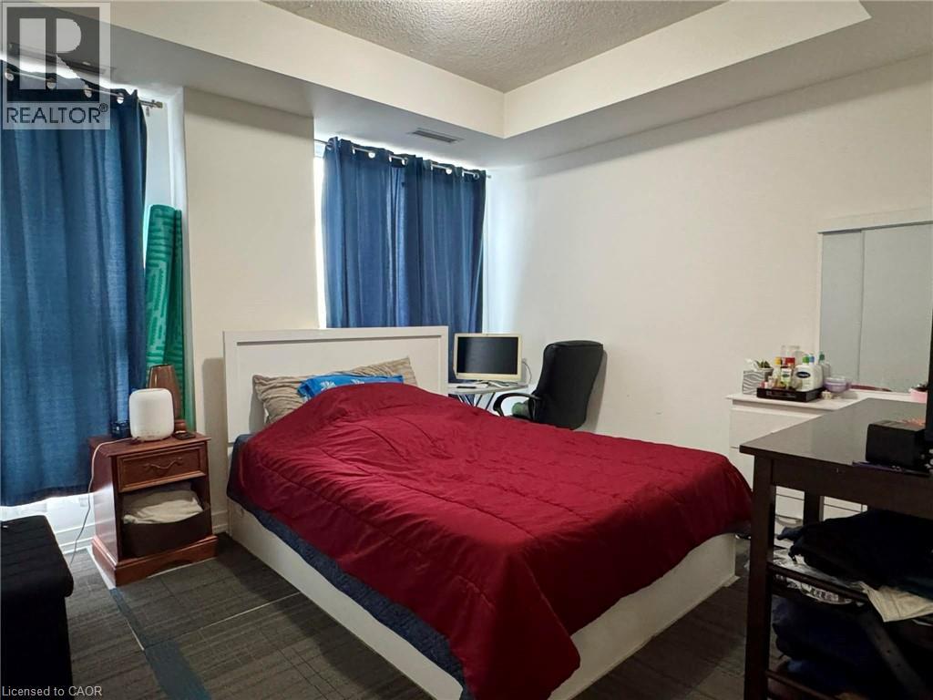 A bedroom with a bed, nightstand, chair, and window.