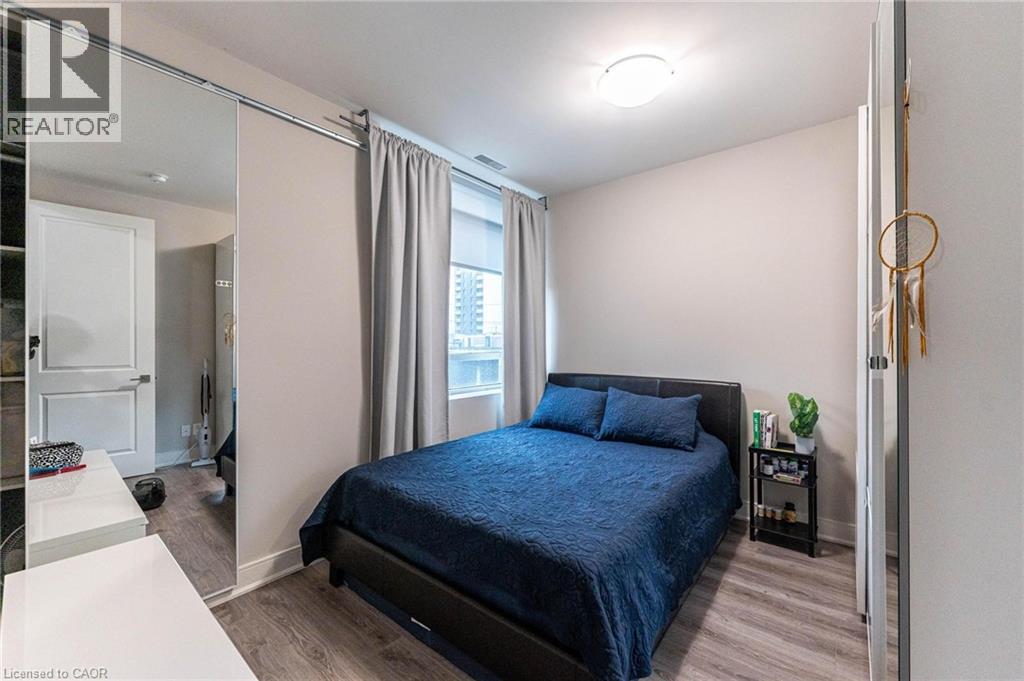 A bedroom with a bed, nightstand, and window.
