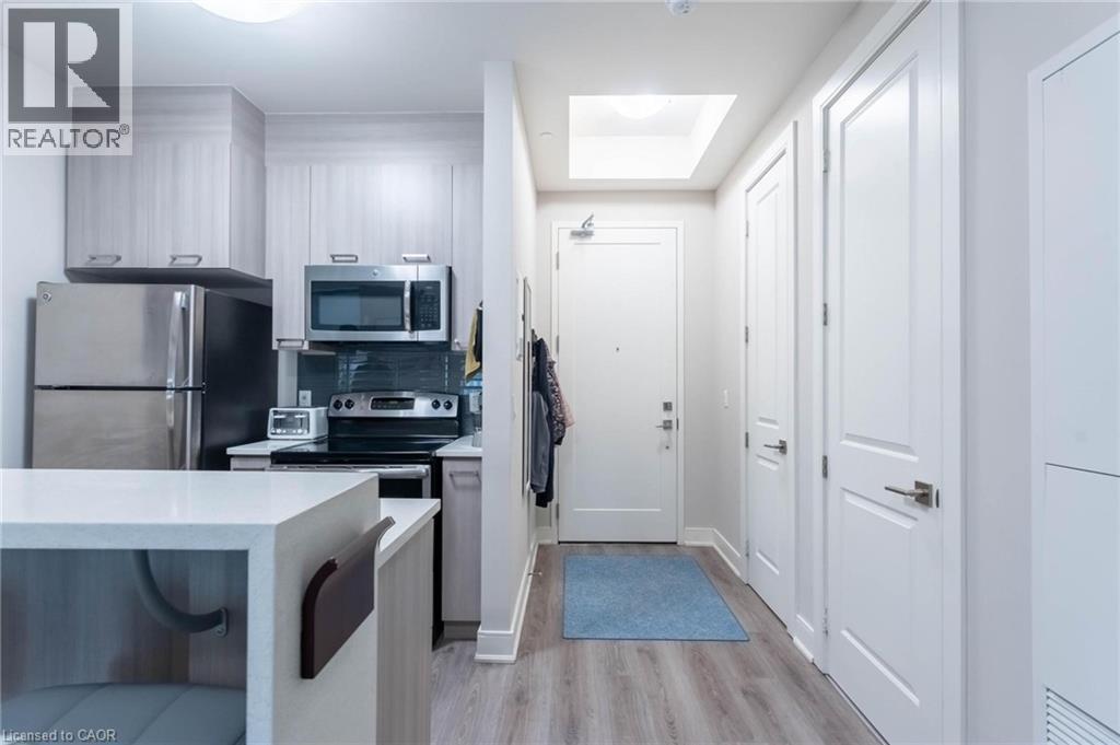 A kitchen with white cabinets and a blue rug on the floor.