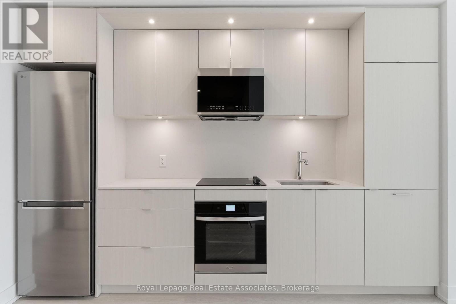 A modern kitchen with white cabinets and stainless steel appliances.