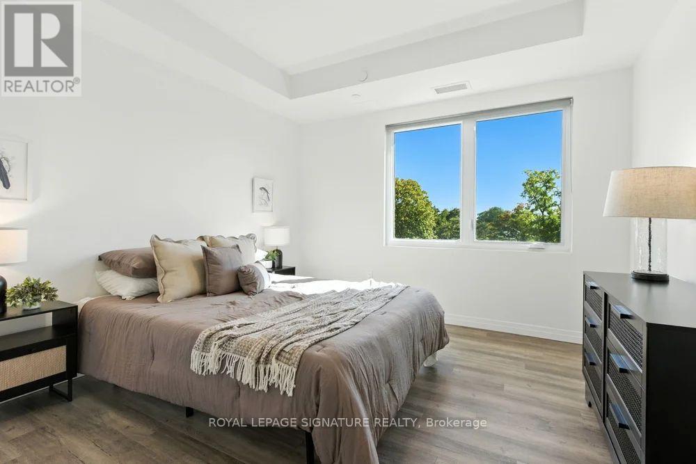 A bedroom with a large bed and a window overlooking trees.