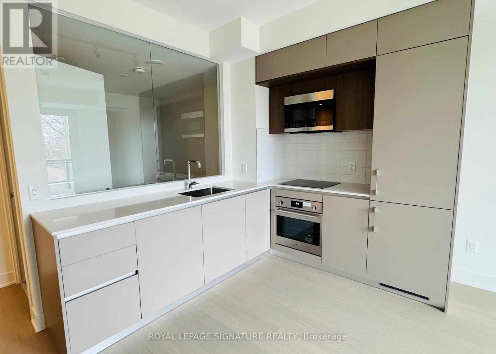 A modern kitchen with white cabinets and stainless steel appliances.