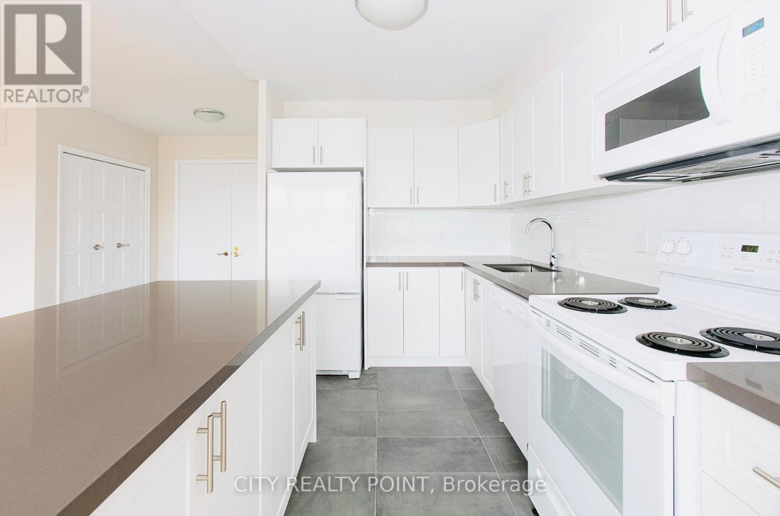 A kitchen with white cabinets and appliances.
