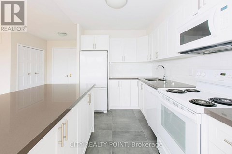 A kitchen with white cabinets and appliances.